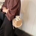 Sac seau beige à texture verticale avec poignée en perles et chaîne dorée en décor studio - Kaki