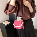 Sac seau rose avec texture plissée, poignée en perles et chaîne dorée sur mannequin - Rose