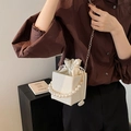 Sac seau plissé blanc avec poignée en perles et chaîne dorée porté par un mannequin - Blanc