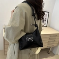 Glänzende schwarze Schultertasche mit silberner Schleife und Knotengurt am Modell - Schwarz