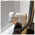 Detail der silbernen Metallic-Ledertasche mit Wellenrand und goldener Trapezschnalle - Silber