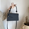 Minimalist black textured crossbody bag with cylindrical top handle and gold hardware - Black