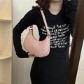 Pale pink crescent bag with silver metal bow and adjustable shoulder strap worn by a model - Pink