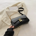 Minimalist black leather baguette bag with golden geometric clasp and chain strap - Black