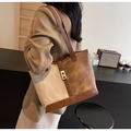 Vista lateral de mujer llevando bolso tote de lona con detalles de cuero marrón en un café - Patchwork Café (Marrón/Beige)