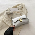Silver metallic crossbody bag with gold hardware and chain strap on beige suit jacket - Silver
