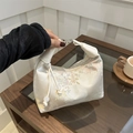 Elegante Satin-Handtasche mit Stickerei im China-Stil auf Holztisch für Teestunde - Weiß