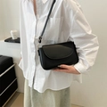 Dettaglio borsa a tracolla nera chic indossata con camicia bianca e gonna casual - Nero