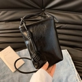 Mini black crossbody bag with spiral knot strap and vintage oily leather texture - Black
