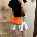 Minimalist orange nylon crossbody bag with chunky chain strap worn by a model - Orange