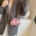 Pink metallic pleated dumpling bag with thin shoulder strap on a fashion model - Pink