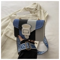 Detalle del bolso bandolera de lona a rayas azules con correa ancha y herrajes dorados - Gris
