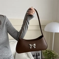 Retro dark brown underarm bag with a silver metallic bow accent in a stylish setting - Brown