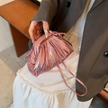 Metallic pink pleated cloud clutch bag with thin strap, shown in an elegant lifestyle setting - Rose Pink