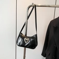 Chic black patent leather baguette bag featuring a textured silver heart rhinestone accent - Black