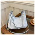 Detail shot of light blue shoulder bag with pleated texture and silver chain on wood table - No Pendant / Blue
