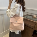 Chic light pink pleated shoulder bag with silver clasp shown on a model in a cafe - Pink