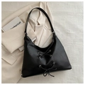 Nahaufnahme der schwarzen Halbmond-Hobo-Tasche mit silbernen Ösen und Schleifenband - Schwarz