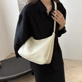 Borsa a spalla minimalista bianco crema con cuciture geometriche indossata da modella - Bianco