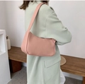 Chic peach pink faux leather underarm bag with matching wide strap worn by a model - Pink