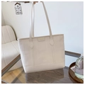 Dettaglio del tessuto testurizzato crema e patch logo in pelle su una grande borsa tote - Bianco Sporco