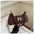 Close-up of brown faux leather half-moon bag featuring a silver bow metal buckle detail - Brown