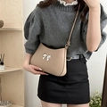 Chic beige crossbody bag with silver bow accent and adjustable shoulder strap - Khaki