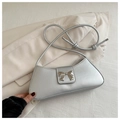 Close-up of metallic silver shoulder bag featuring a decorative metal bow and slim strap - Silver