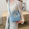 French style light blue quilted handbag with silver bow detail for women in lifestyle setting - Blue