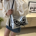 Metallic silver Y2K butterfly shoulder bag with lace-up detail worn by model - Black and Silver