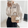 Dettaglio della borsa beige strutturata con scanalature alla moda e ciondolo a nuvola - Cachi
