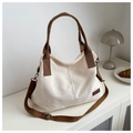Detail of canvas tote bag with leather fashion tag and adjustable shoulder strap - White