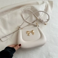 Elegante cremeweiße Satteltasche mit einer markanten goldenen Schleife verziert - Weiß