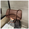 Detailed view of dark brown shoulder bag with unique wave stitching and dual straps - Brown