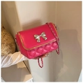 Rose red quilted crossbody bag featuring silver bow clasp and woven chain strap - Red