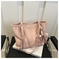 Close-up of pink marble tote bag with silk scarf on a book and black chair - Pink