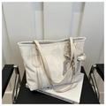 Detail of off-white tote bag with marble texture and silk scarf on a leather seat - White