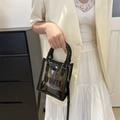 Clear PVC jelly handbag with black trim and OWU logo, worn with cross-body strap - Dark Brown
