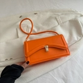 Vibrant orange shoulder bag with quilted lines and golden buckle on white suit background - Orange