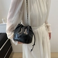 Borsa a secchiello nera con coulisse, tracolla a catena oro e dettaglio logo moda - Nero