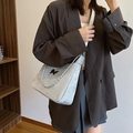 Silver textured shoulder bag with black butterfly logo and stylish chain strap detail - Silver