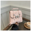 Detail van roze handtas met strik, zilveren gespen, matte textuur en handvat - Roze