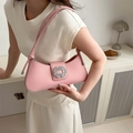 Pink leather underarm bag with rhinestone buckle shown on a model in a minimal setting - Pink