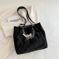 Borsa tote nera a pieghe con catena d'argento e ciondolo a farfalla su blazer beige - Nero