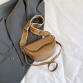 Retro tan zadeltas met brede gestreepte riem en dunne leren riem op een grijze blazer achtergrond - Bruin