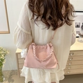 Borsa tote rosa chiaro con manico intrecciato e ciondolo di peluche, indossata dal modello - Con Ciondolo / Rosa