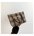 Detail der karierten Woll-Tote-Bag mit goldener Kette und Hirsch-Metallanhänger - Grau