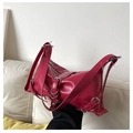 Detalle de bolso fucsia en charol plisado con hebillas metálicas plateadas de moda - Rosa Rojo