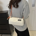 White corduroy cylinder crossbody bag with orange rope strap and fashion label detail - White