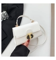 Close-up of white leather square bag featuring a T-shaped gold buckle and top handle - White